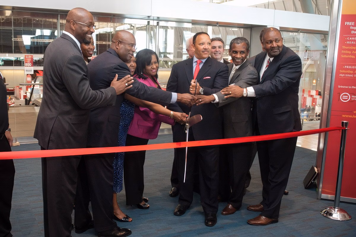 Group of people participating in a ribbon-cutting ceremony at a Boston corporate event.